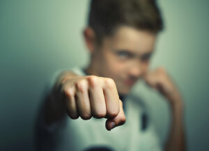 Angry child boy in white t-shirt training box punch.